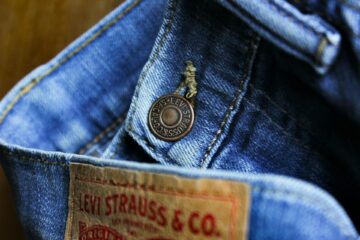 A close-up of classic Levi Strauss & Co. jeans, highlighting their iconic button detail and signature denim texture.