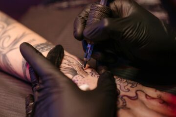 A close-up of an artist tattooing intricate designs, showcasing the expertise found in tattoo studios in Shoreditch.