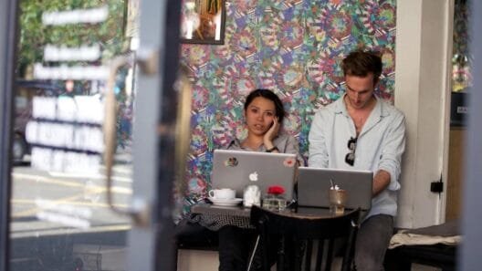 Two young professionals working on laptops in a trendy Shoreditch café, reflecting the energy of Shoreditch startups.
