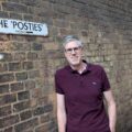 Huw Jones, author of The Last Director of Shoreditch, standing by a brick wall in East London, reflecting Shoreditch’s history.