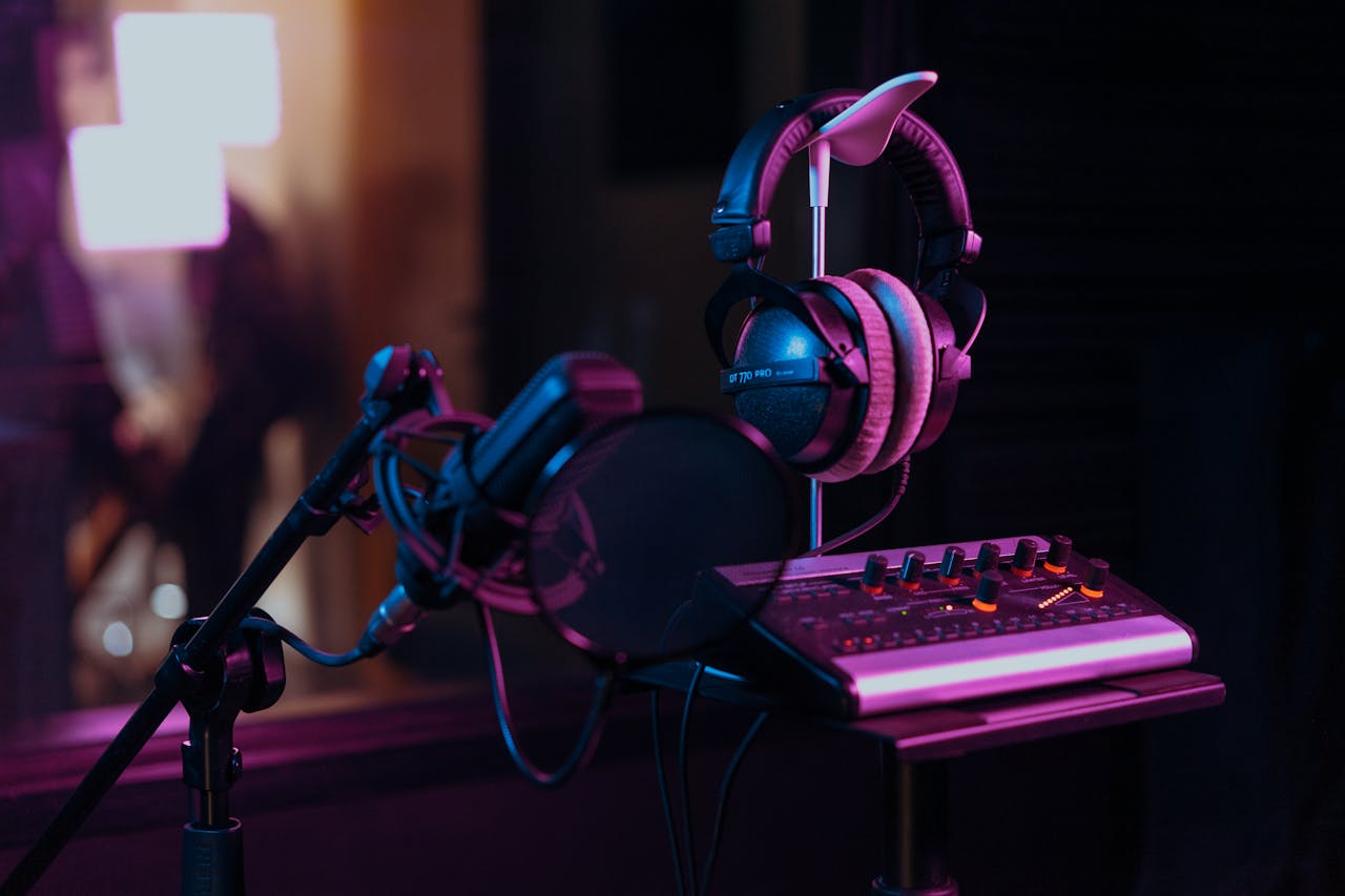 SEO-optimized alt text: “Professional recording setup with headphones, microphone, and mixer in a dimly lit studio at recording studios in Shoreditch.”