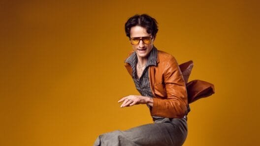 Jazz Emu performs in full disco persona on stage with synth backdrop