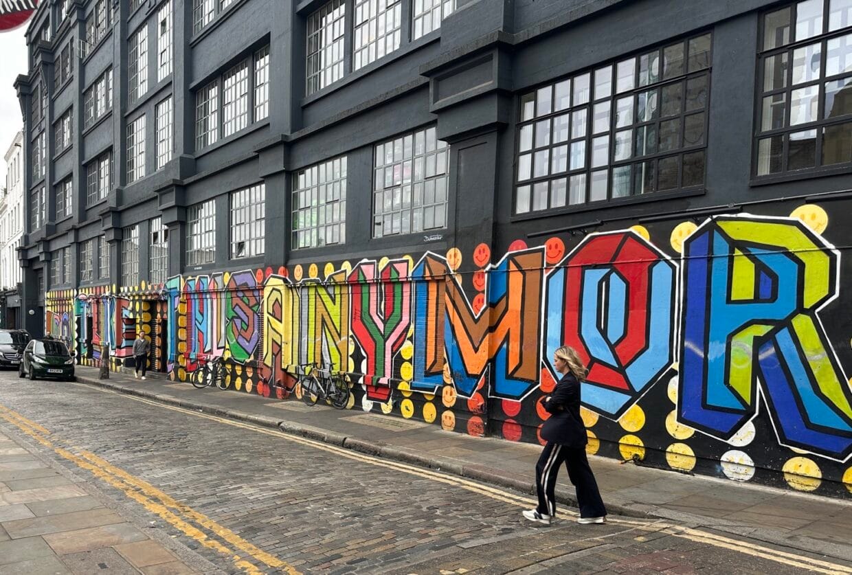 Colourful Shoreditch street art with person walking by