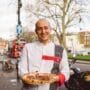 Andrea Asciuti holding Neapolitan pizza in front of 081 Pizzeria