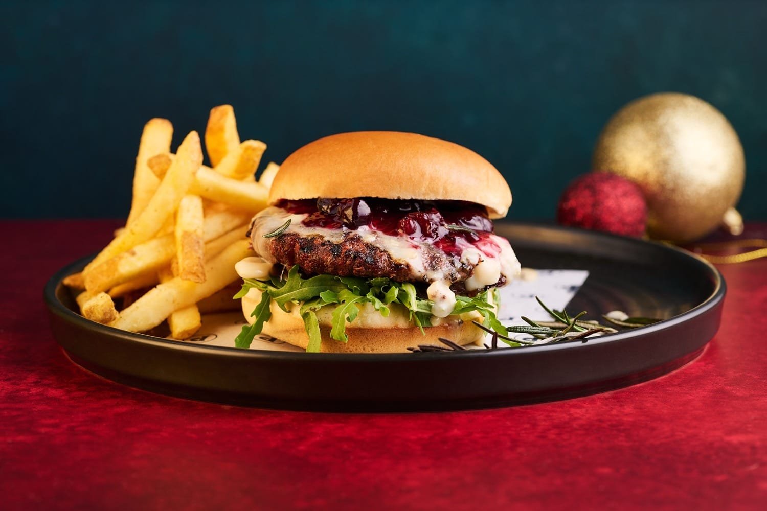 Inside the New Puttshack Festive Menu Taking Over London This Christmas 7 The Winter Stack burger from the Puttshack festive menu with truffle mayo, gorgonzola, cranberry sauce and winter greens on a warm festive plate.