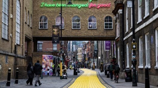 Neon lyric installation above the Truman Brewery Bridge illuminating the Wicked Yellow Brick Lane walking trail.