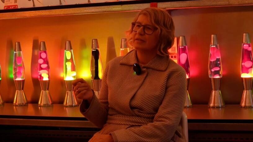 Cressida Granger, CEO of Mathmos, standing with an iconic lava lamp