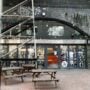 The front of All My Gods bar on Paradise Row in Bethnal Green, with benches outside a railway arch
