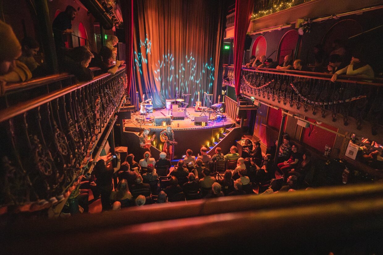 The two-tier galleried auditorium of Hoxton Hall on Hoxton Street, lit for a concert