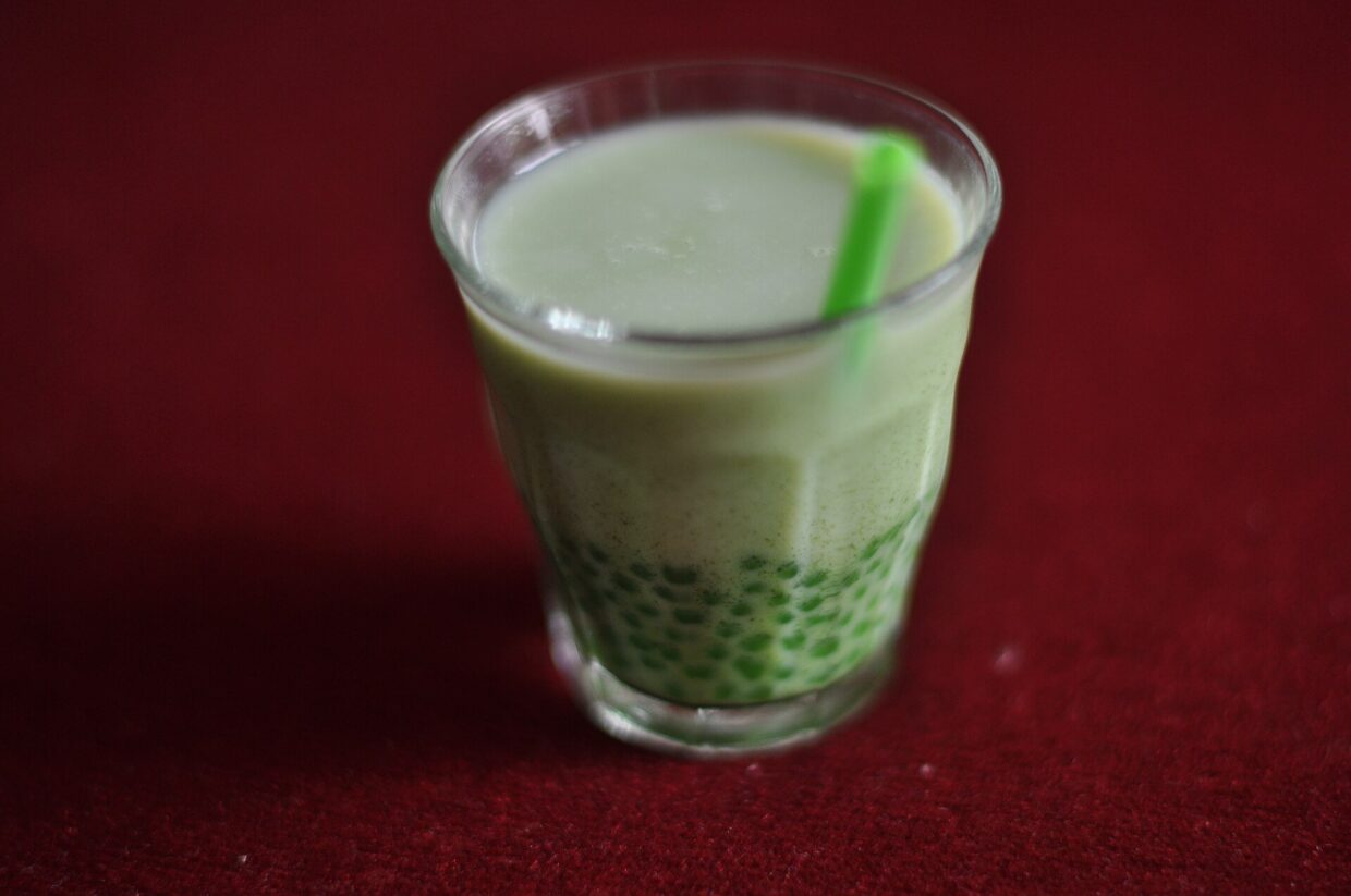 A cup of matcha bubble tea with tapioca pearls