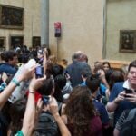 Crowd of visitors photographing the Mona Lisa at the Louvre