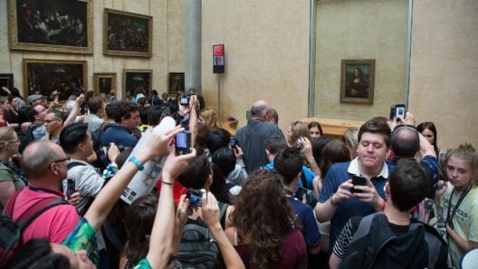 Crowd of visitors photographing the Mona Lisa at the Louvre